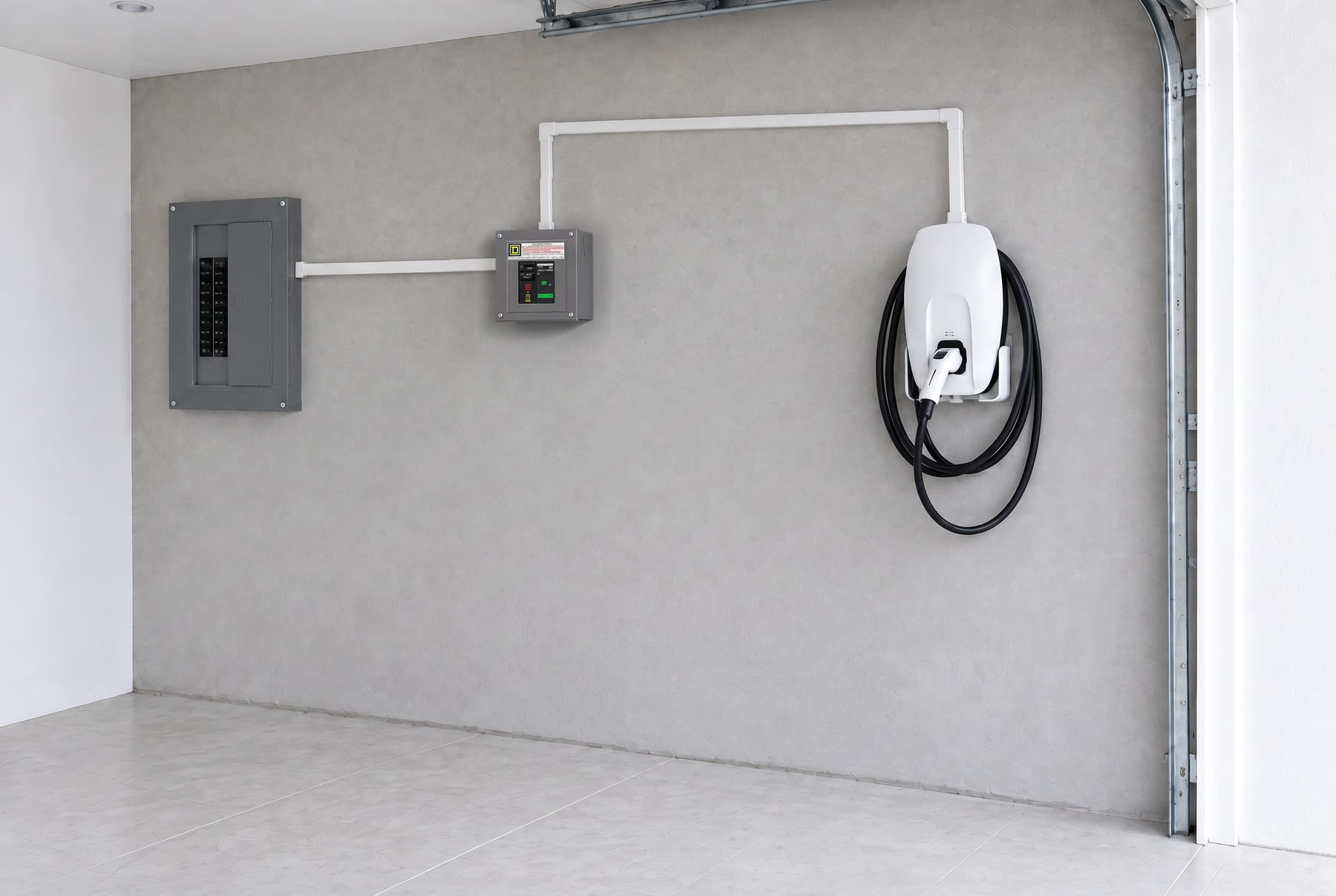 Cochera con el centro de carga de la casa, un centro de carga dedicado y el cargador de pared, unidos con canaleta blanca